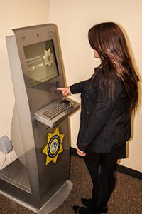 A woman uses the Ventura County Probation kiosk