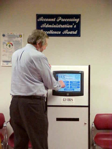 History of kiosks: A man using a DynaTouch self-service kiosk at the IRS, showcasing the evolution of convenient self-service technology.